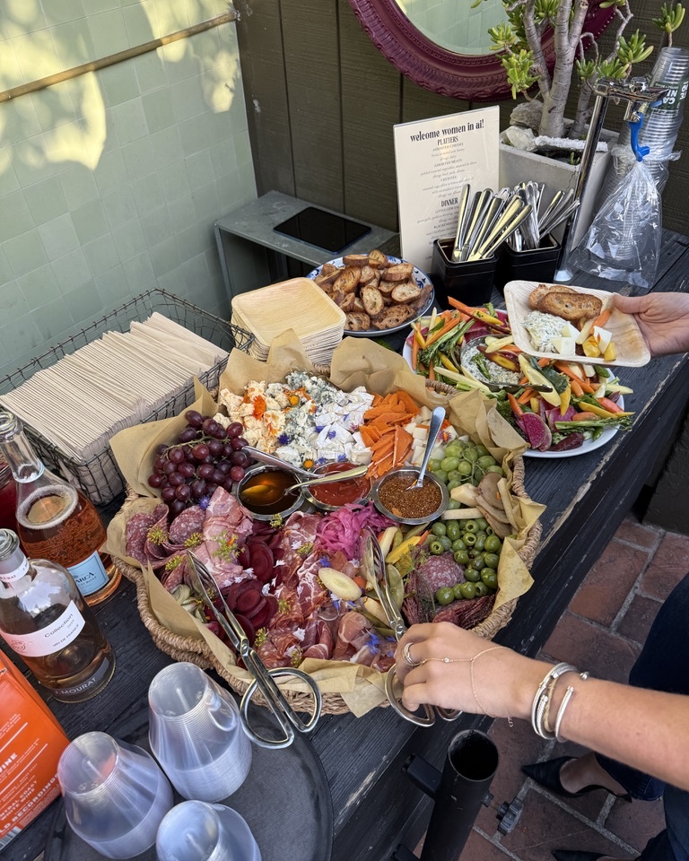 A spread of food and wine at a Women + AI dinner.